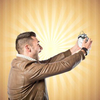 antika saat koyu sarı bir arka plan üzerinde tutan genç işadamı 