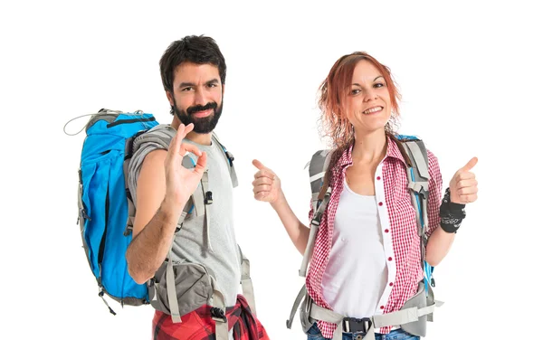 Backpacker making Ok sign over white background — Stock Photo, Image