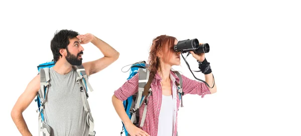 Backpacker with binoculars over isolated white background — Stock Photo, Image