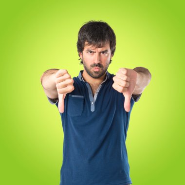 Yeşil arka plan üzerinde kötü bir sinyal yapan erkek