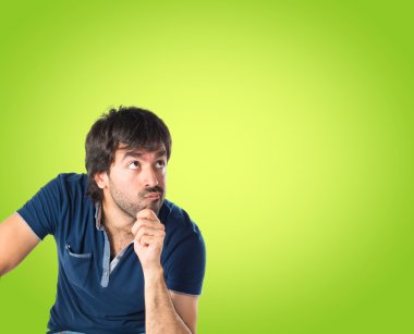 Adam yeşil arka plan üzerinde düşünme