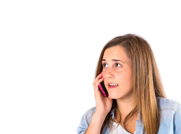 Menina conversando com celular sobre fundo branco — Fotografia de Stock