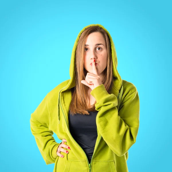 Menina fazendo gesto de silêncio sobre fundo azul — Fotografia de Stock