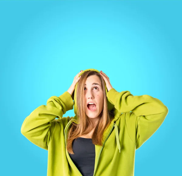 Young girl doing surprise gesture over blue background — Stock Photo, Image