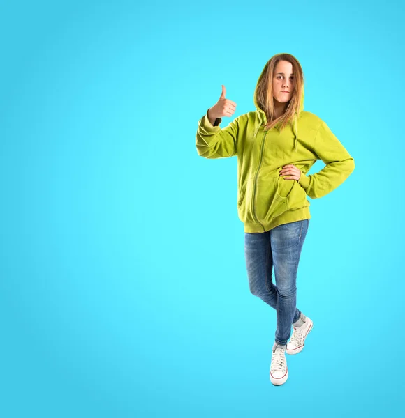 Girl with thumb up over blue background — Stock Photo, Image