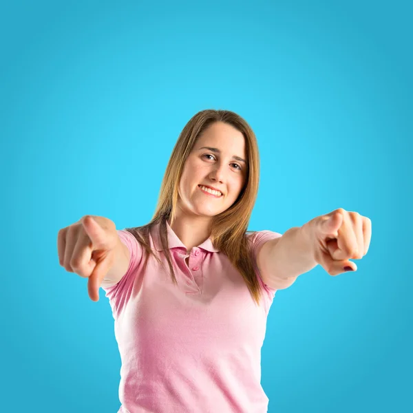 Junge hübsche Frau zeigt auf blauen Hintergrund — Stockfoto