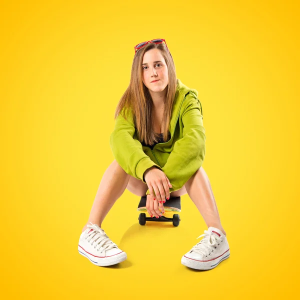 Blondes Mädchen mit Schlittschuhen auf gelbem Hintergrund — Stockfoto