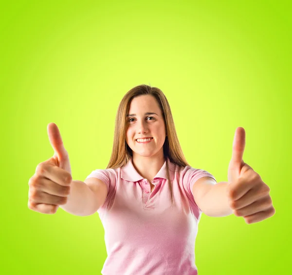 Young girl making Ok sign over green background — Stock Photo, Image