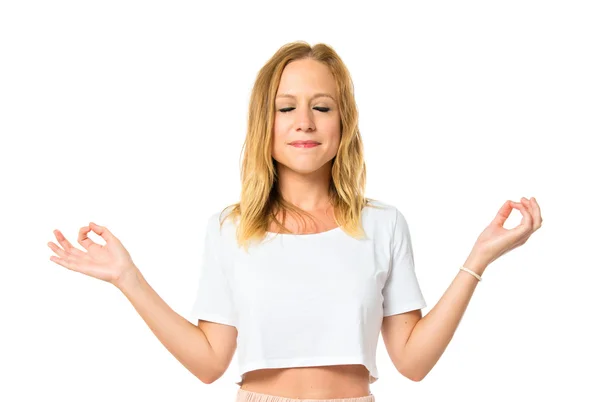 Blondes Mädchen in Zen-Position über weißem Hintergrund — Stockfoto