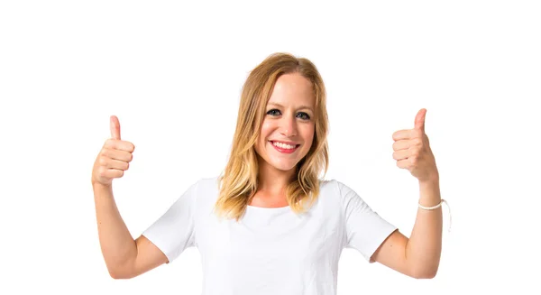 Blonde girl with thumbs up over white background — Stock Photo, Image