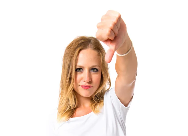 Chica haciendo una mala señal sobre fondo blanco — Foto de Stock