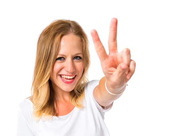 Roztomilá žena, která dělá gesto vítězství nad bílým pozadím — Stock fotografie