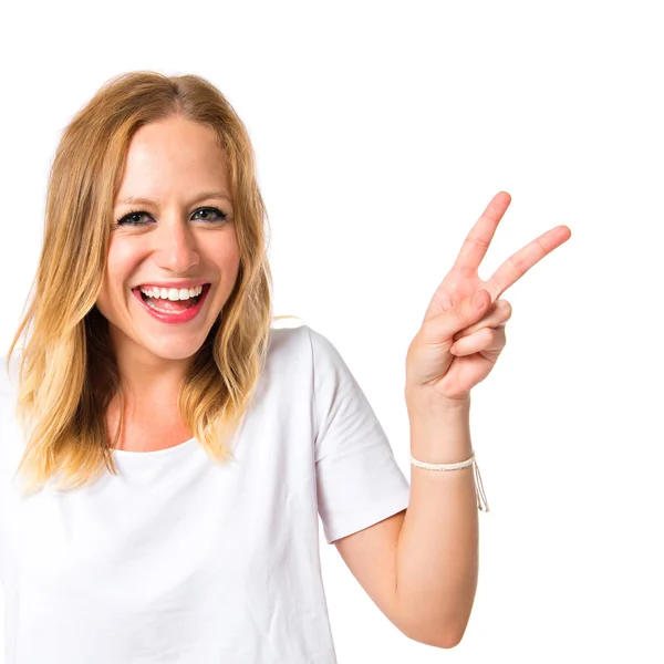 Cute woman doing victory gesture over white background — Stock Photo, Image