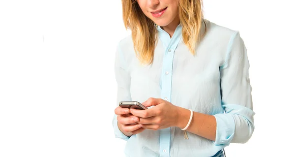 Menina loira falando com celular sobre fundo branco — Fotografia de Stock