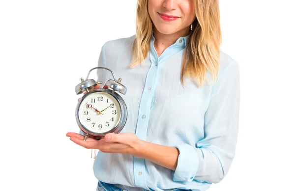 Menina segurando um relógio sobre fundo branco — Fotografia de Stock
