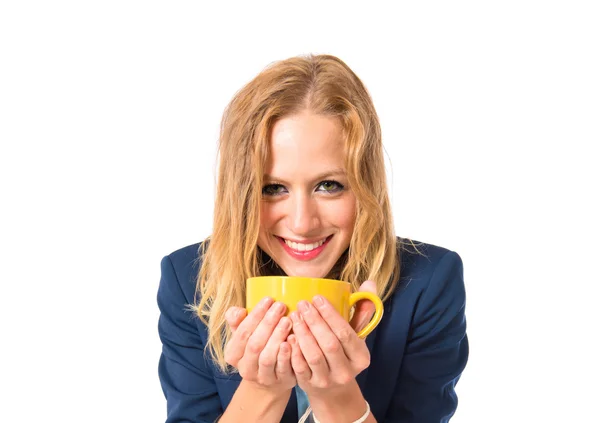 Blond tjej innehar en kopp kaffe över vit bakgrund — Stockfoto