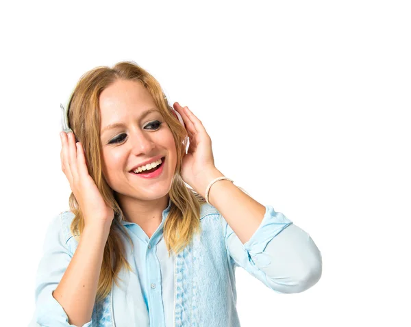 Junge Frau hört Musik vor weißem Hintergrund — Stockfoto