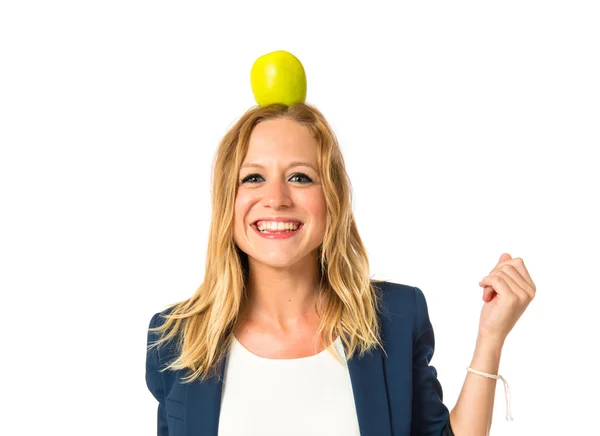 Blondes Mädchen mit Apfel über dem Kopf auf weißem Hintergrund — Stockfoto