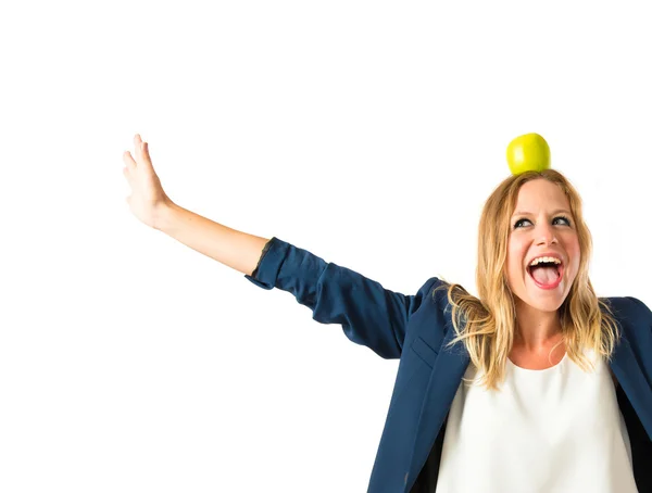 Chica rubia con manzana por encima de su cabeza sobre fondo blanco —  Fotos de Stock