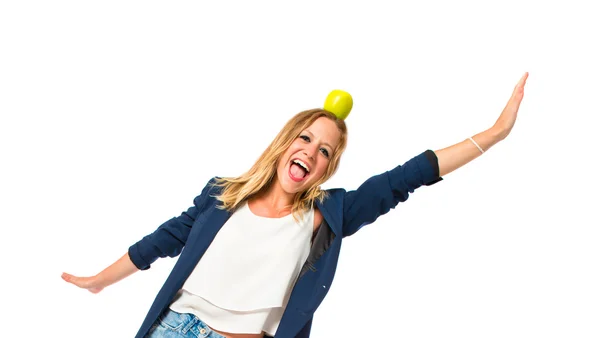 Blonde girl with apple above her head over white background — Stock Photo, Image