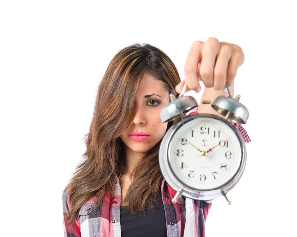Girl holding a clock over white background — Stock Photo, Image