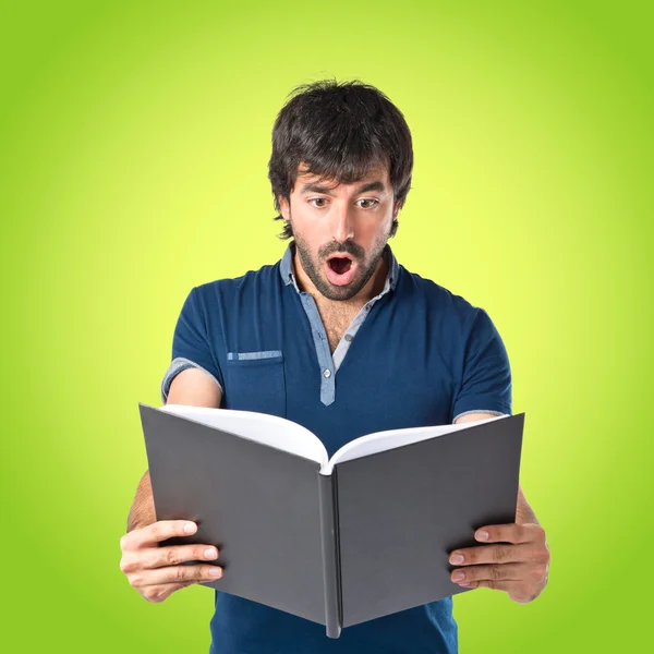 Uomo che legge un libro su sfondo verde — Foto Stock