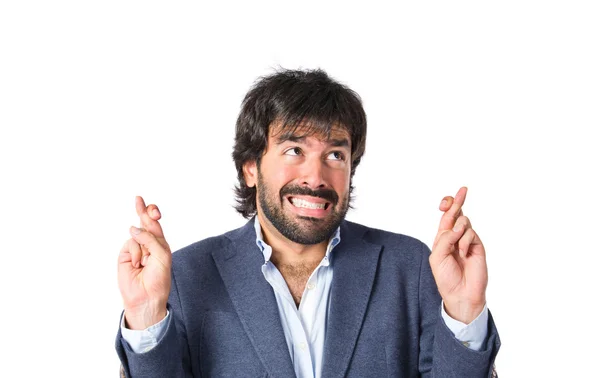 Man with his fingers crossing over white background — Stock Photo, Image