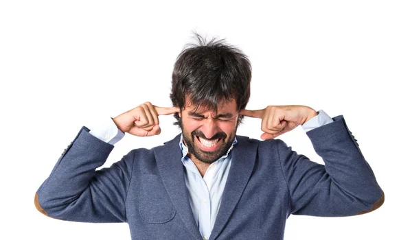 Hombre cubriéndose las orejas sobre fondo blanco — Foto de Stock