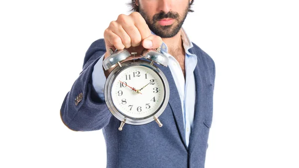 Geschäftsmann hält eine Uhr vor weißem Hintergrund — Stockfoto