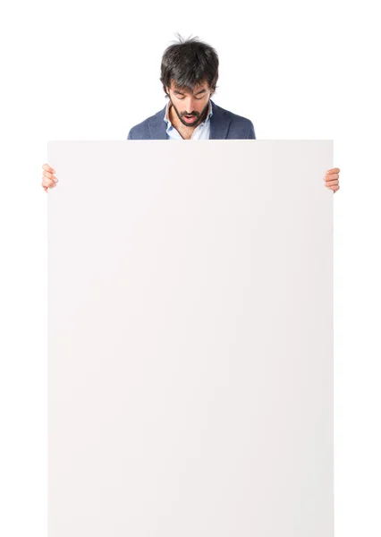 Empresário com cartaz vazio sobre fundo branco idolatrado — Fotografia de Stock