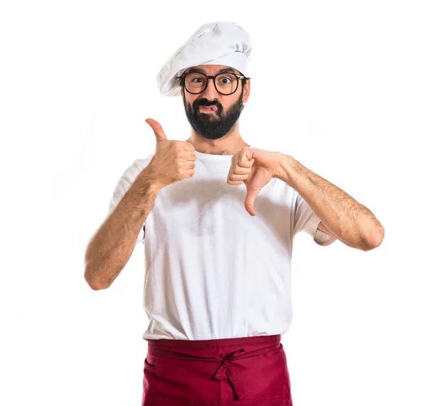 Chef facendo un buon-cattivo segno su sfondo bianco — Foto Stock