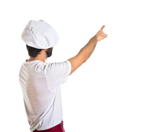 Chef apuntando hacia atrás sobre fondo blanco — Foto de Stock