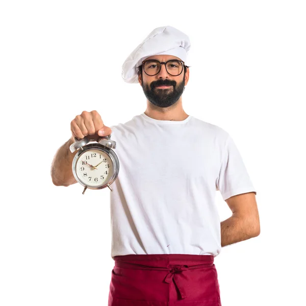 Chef tenant une horloge sur fond blanc — Photo