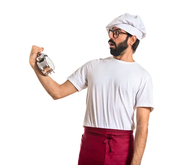 Überraschter Koch mit Uhr vor weißem Hintergrund — Stockfoto