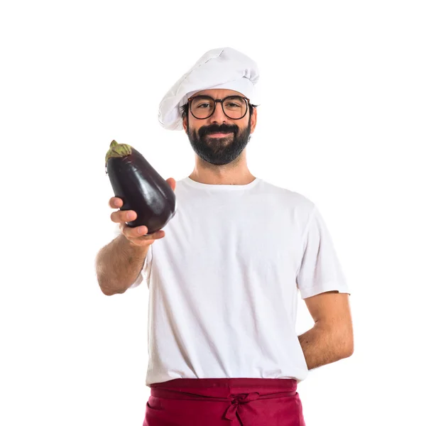 Koch hält Aubergine in der Hand — Stockfoto