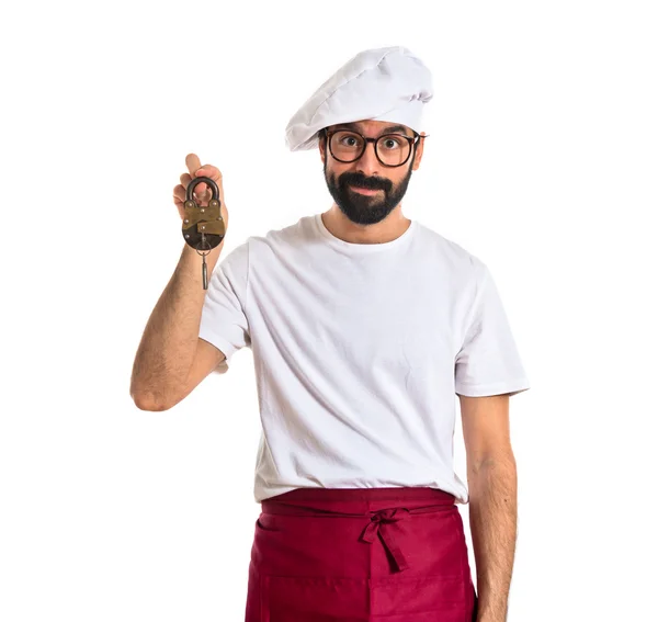 Шеф-повар держит винтажный замок на белом фоне — стоковое фото