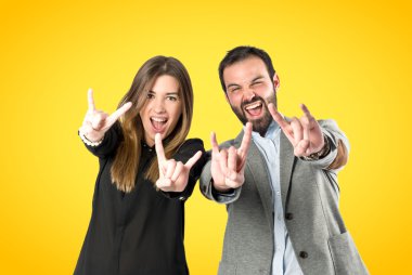 Boynuz yapıyor çift sarı arka plan üzerinde oturum 