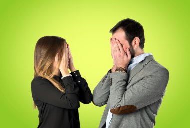 Yeşil arka plan üzerinde gözlerini kapsayan Çift 