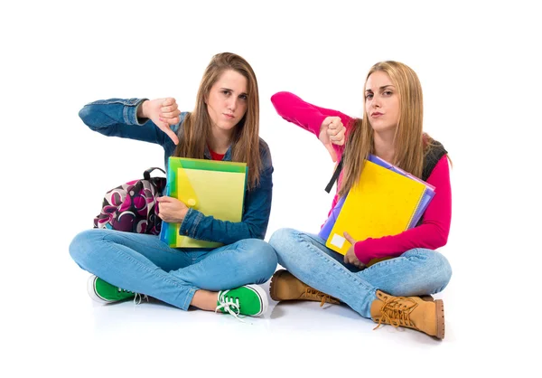 Estudiantes haciendo una mala señal sobre fondo blanco — Foto de Stock