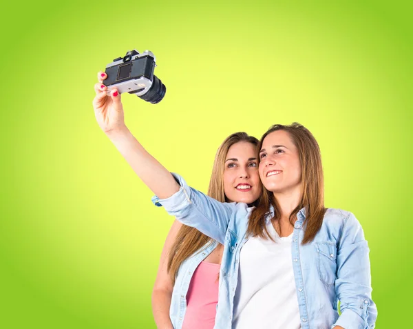 Girl photographing over green background — Stock Photo, Image