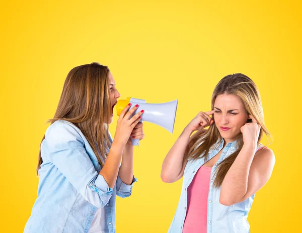 Jente skriker med en megafon på sin venn – stockfoto