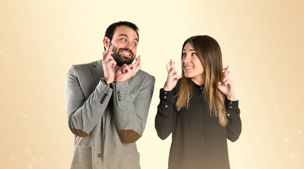 Casal com os dedos cruzando sobre fundo brilho — Fotografia de Stock