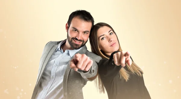 Couple pointing to the front over gloss background — Stock Photo, Image