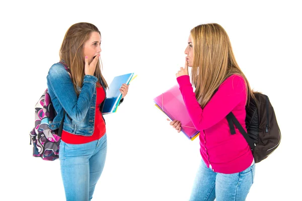 Student making silence gesture at her friend Stock Image