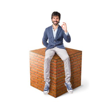 Büyük taş öğe üzerinde bir saat tutan adam 