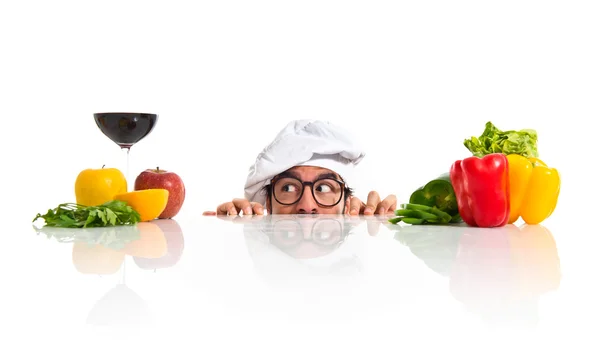 Crazy hipster chef hiding behind the table — Stock Photo, Image