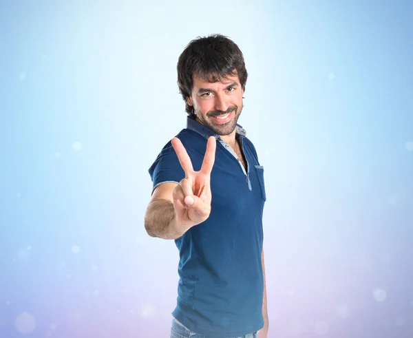 Man doing victory gesture over white background — Stock Photo, Image