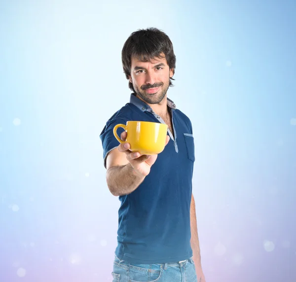 Muž, který držel šálek kávy nad modrým pozadím — Stock fotografie
