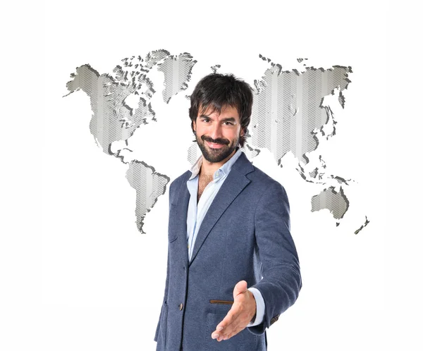Businessman making a deal over atlas background — Stock Photo, Image