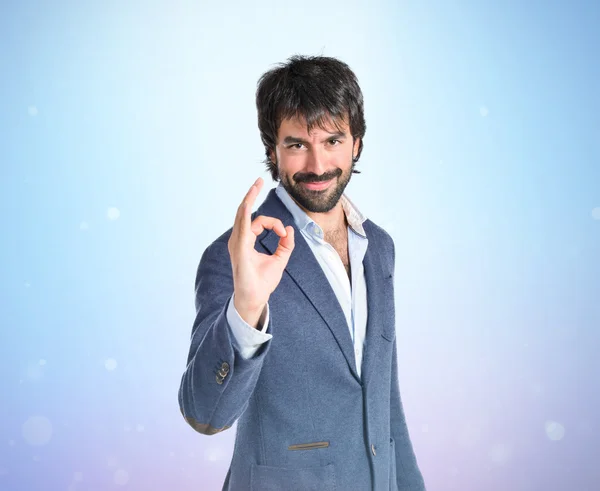 Businessman making Ok sign over blue background — Stock Photo, Image